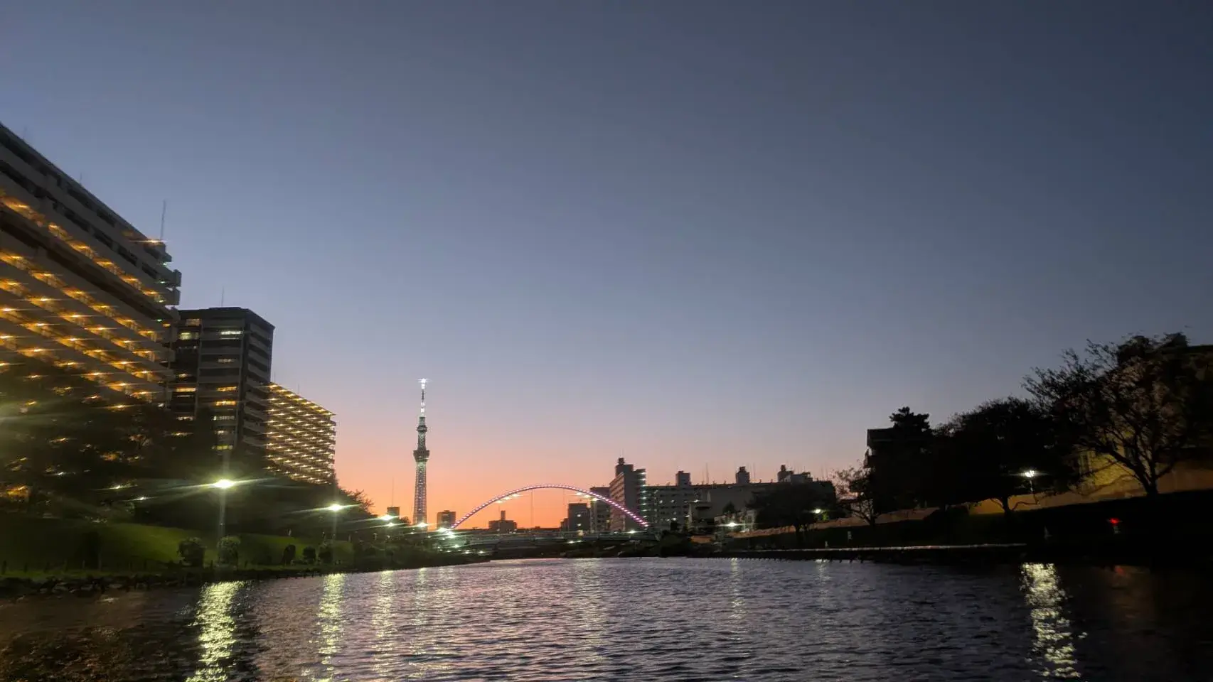 カヤックから見た、ライトアップされた旧中川・ふれあい橋と東京スカイツリーの夕景
